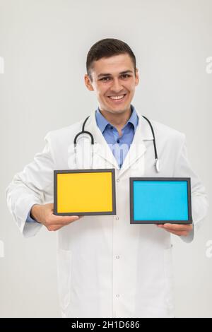 Mr. Doctor holds two picture frames or lettering in blue and yellow. Stock Photo