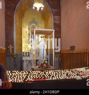 Lourdes, France - 9 Oct, 2021: Candles at a shrine to the Virgin Mary within the Rosary Basilica Church Stock Photo