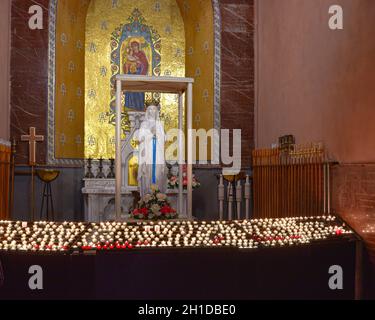 Lourdes, France - 9 Oct, 2021: Candles at a shrine to the Virgin Mary within the Rosary Basilica Church Stock Photo