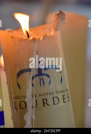 Lourdes, France - 9 Oct 2021: Candles glow at a shrine within the Rosary Basilica of Lourdes catholic pilgrimage site Stock Photo