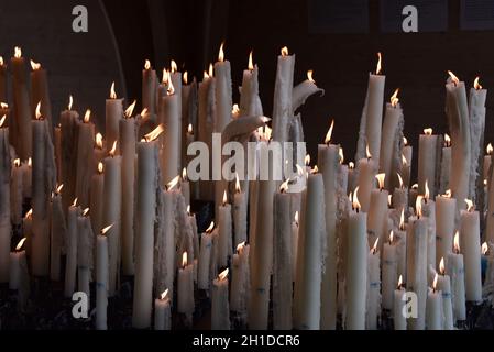 Lourdes, France - 9 Oct 2021: Candles glow at a shrine within the Rosary Basilica of Lourdes catholic pilgrimage site Stock Photo