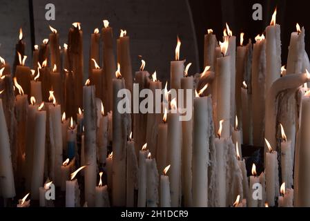 Lourdes, France - 9 Oct 2021: Candles glow at a shrine within the Rosary Basilica of Lourdes catholic pilgrimage site Stock Photo