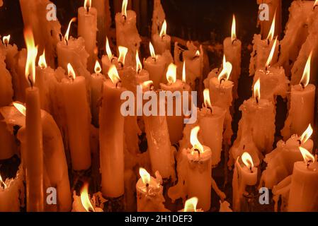 Lourdes, France - 9 Oct 2021: Candles glow at a shrine within the Rosary Basilica of Lourdes catholic pilgrimage site Stock Photo