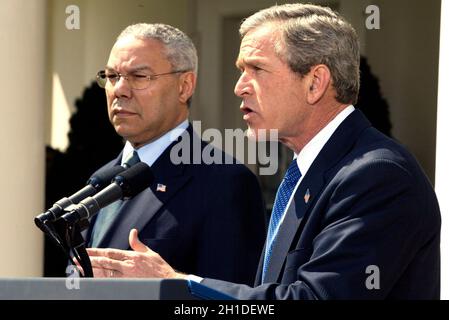 United States President George W. Bush makes an announcement in concerning his Middle East policy in the Rose Garden of the White House in Washington, DC on April 4, 2002 as US Secretary of State Colin Powell looks on. Credit: Ron Sachs/CNP Stock Photo
