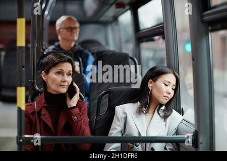 Portrait of young Asian woman sleeping on bus while traveling by public transport in city Stock Photo