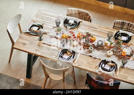 High angle view of wooden dining table serving with beautiful dishes decorated in autumn style Stock Photo