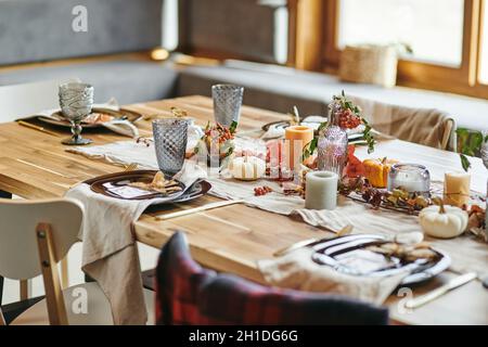Close-up of beautiful autumn decoration from candles vegetables and branches on dining table Stock Photo