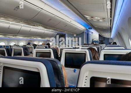 Airplane cabin interrior sold out flight full of passengers on economy class