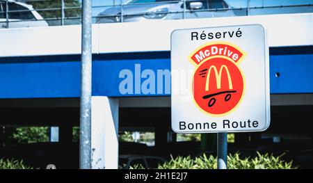Libourne, France - May 26, 2017: Road sign indicating a place reserved for McDrive customers in the parking lot of a McDonald s restaurant on a spring Stock Photo