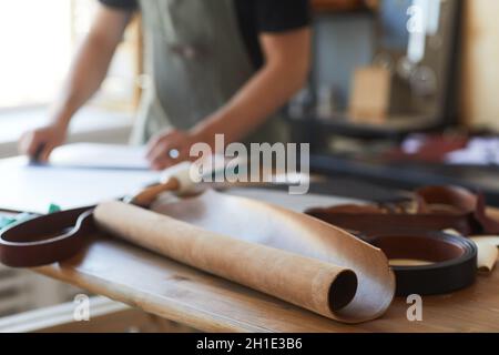 Close up of genuine leather on wooden table in tanners workshop, copy space Stock Photo