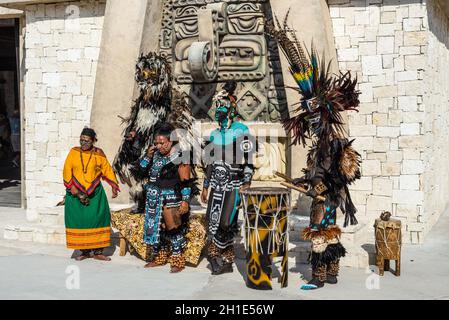 Costa Maya, Mexico - April 25, 2019: Local people in colorful traditional costumes drum and dance to entertain tourists outside the Costa Maya village Stock Photo