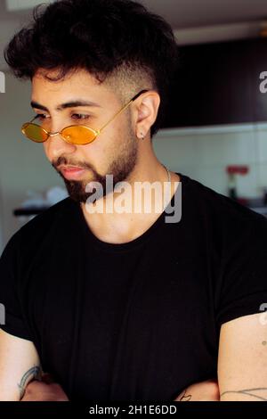 Portrait of a young Hispanic man wearing yellow sunglasses Stock Photo