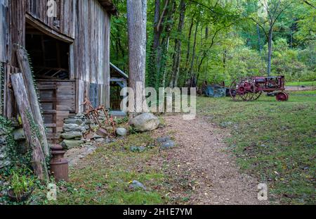 Antique Farmall F-14 tractor near barn at Ely's Mill along the Roaring Fork Motor Nature Trail in the Great Smoky Mountains National Park Stock Photo