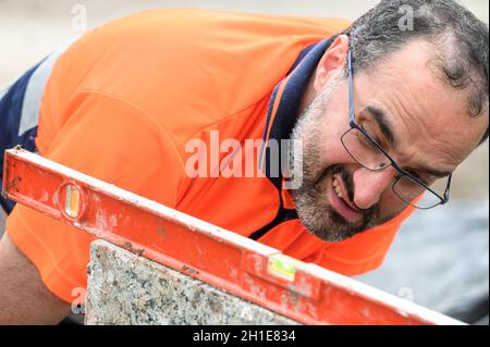 Construction worker checking the bubble level while working at construction site. Building construction . Stock Photo