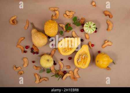 Small pumpkins, dried apples and cranberries on brown paper background. Top view. Stock Photo