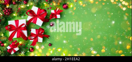 Gift Boxes On Green With Fir Branches And Christmas Ornament - Presents With Red Ribbon And Bokeh Lights Stock Photo