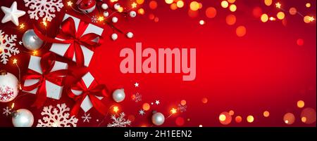 Gift Boxes On Red With Christmas Ornaments - Presents With Bokeh Lights And Snowflakes Stock Photo