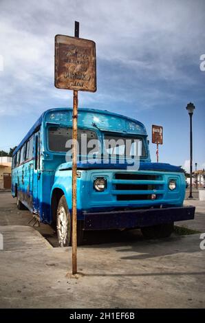 Chelem, Mexico - October 14th, 2007: Rusty old blue coach standing next to bus stop. Route: Chuburna - Isstey Spa - Chelem Naval Zone. Stock Photo