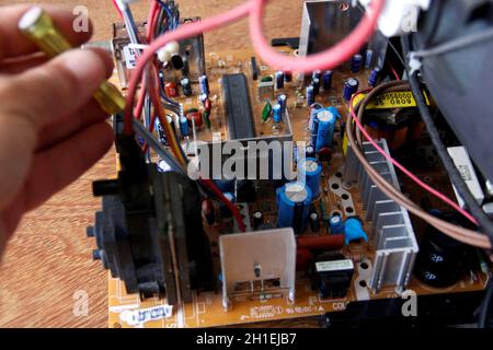 salvador, bahia / brazil - october 17, 2014: technician checking electronic television circuit board in the city of Salvador. *** Local Caption ***  . Stock Photo