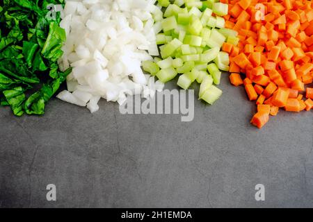 Chopped Spinach with Diced Onions, Celery, and Carrots: Chopped vegetables on a dark background with room for copy Stock Photo