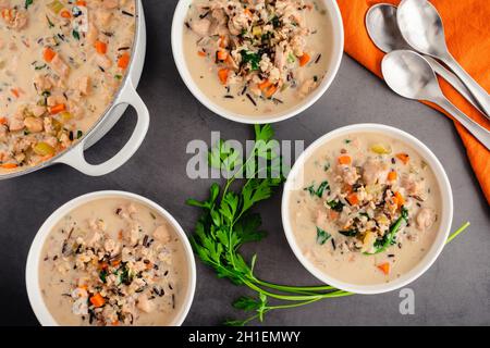 Bowls of Chicken and Wild Rice Soup: Overhead view of creamy chicken and wild rice soup with spinach and carrots Stock Photo