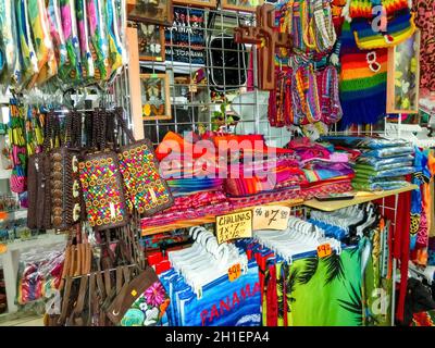 Ethnic souvenirs, baseball caps, bags with various pattern hanging in ...