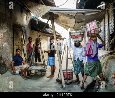 Chittagong, Bangladesh, December 22, 2017: Men weighing baskets with salt at a factory in Chittagong, Bangladesh Stock Photo