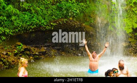 Soufriere, Saint Lucia - May 12, 2016: The tourists swimming at the waterfall at the Botanical Gardens in Saint Lucia at island at Caribbean sea Stock Photo