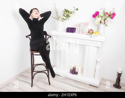 Senior woman at home sitting on modern chair and relaxing in her living room Stock Photo