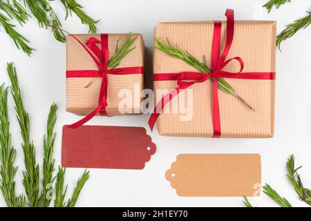 Gift boxes packed in craft paper with simple decor of green plant branches Stock Photo