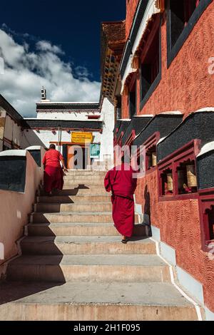 THIKSEY, INDIA - SEPTEMBER 13, 2012: Young Buddhist monks walking on stairs along prayer wheels in Thiksey gompa Tibetan Buddhist monastery, Ladakh, I Stock Photo