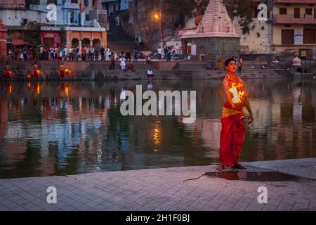 UJJAIN, INDIA - APRIL 23, 2011: Brahmin performing Aarti pooja ceremony on bank of holy river Kshipra. Aarti is Hindu religious ritual of worship, par Stock Photo