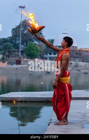 UJJAIN, INDIA - APRIL 23, 2011: Brahmin performing Aarti pooja ceremony on bank of holy river Kshipra. Aarti is Hindu religious ritual of worship, par Stock Photo