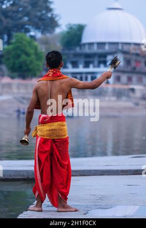 UJJAIN, INDIA - APRIL 23, 2011: Brahmin performing Aarti pooja ceremony on bank of holy river Kshipra. Aarti is Hindu religious ritual of worship, par Stock Photo