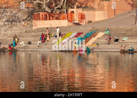 UJJAIN, INDIA - APRIL 25, 2011: People bathing and washing clothes in the morning on ghats of holy Kshipra river. Shipra is one of the sacred rivers i Stock Photo