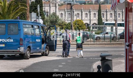 Lisbon, Portugal - May 7, 2018: Policeman chatting with passers-by next to a Portuguese police truck in the historic city center on a spring day Stock Photo
