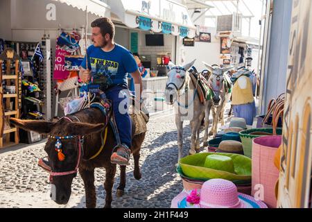 SANTORINI, GREECE - APRIL, 2018: Traditional donkeys and stores at Perissa beach in Santorini Island Stock Photo