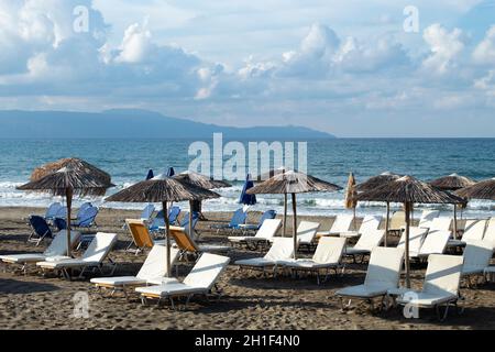 Beautiful Agia Marina, Chania Crete, Greece  Charming Greek beach scene  Sun loungers on the sands with view over the sea to mountains  Landscape aspe Stock Photo