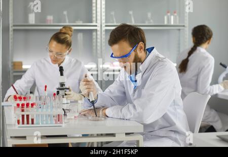 Portrait of three scientists doing research studying substances in modern laboratory Stock Photo
