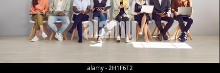 Diverse people waiting in line for their job interviews or business appointments Stock Photo