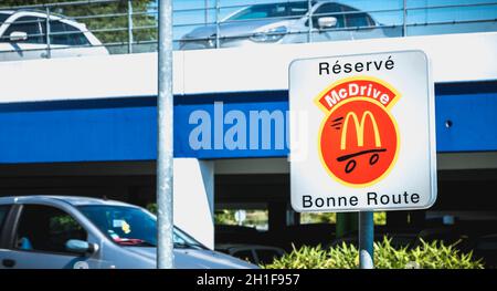 Libourne, France - May 26, 2017: Road sign indicating a place reserved for McDrive customers in the parking lot of a McDonald s restaurant on a spring Stock Photo