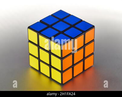 BUDAPEST, HUNGARY - CIRCA 2019: Solved Rubik's cube logic game on shiny metal surface evenly lit from all sides Stock Photo