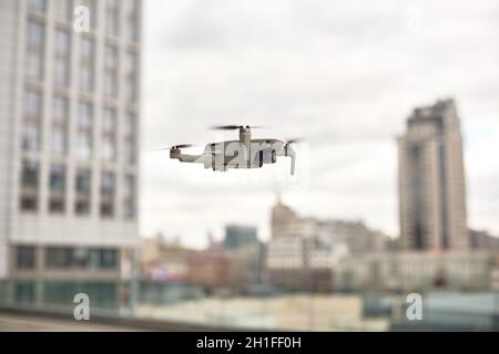 drone fly in city center. exploring new building with innovative technology taking aerial photos and videos from above Stock Photo