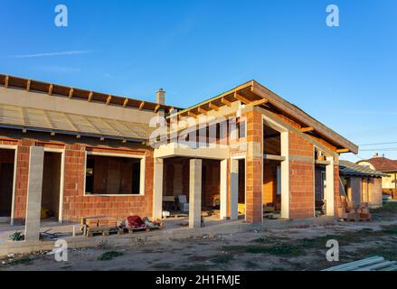 house under constraction with modern brick walls and holes for doors and windows Stock Photo