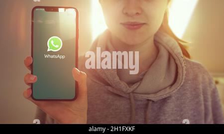 KYIV, UKRAINE-JANUARY, 2020: Whatsapp on Mobile Phone Screen. Young Girl Showing Smartphone Screen with Whatsapp on it while Looking at the Camera. Fo Stock Photo