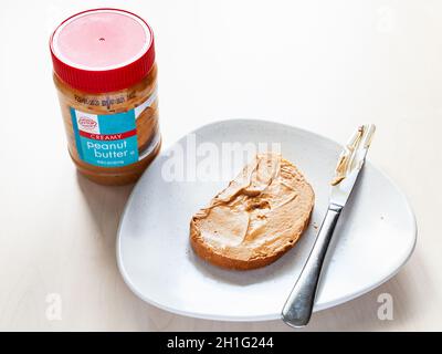 Jar and knife with creamy peanut butter on white background Stock Photo by  ©NewAfrica 193150800