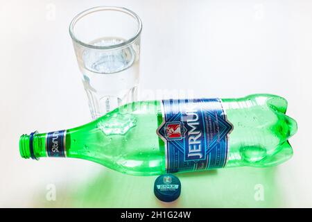 MOSCOW, RUSSIA - JUNE 16, 2020: lying empty plastic bottle of Jermuk and glass with water on table. Jermuk is mineral water from the town of Jermuk in Stock Photo