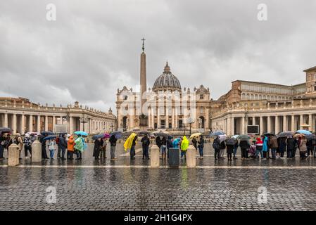 Vatican City State - November 8, 2019: Visitors waiting under rain in the queue to enter in the St Peter's Basilica in Vatican City. Vatican is the in Stock Photo