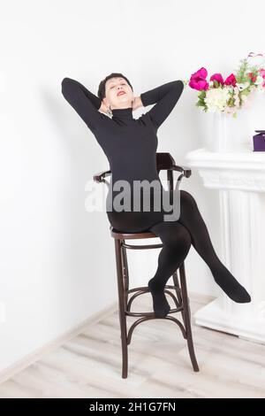 Senior woman at home sitting on modern chair and relaxing in her living room Stock Photo