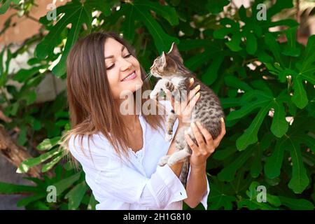 happy careful girl holding kitten in hands and play Stock Photo